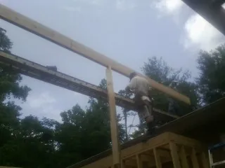 Carpenter setting a ridge beam over a new addition frame — Ice Dam Removal by Roofing Brothers in Ava